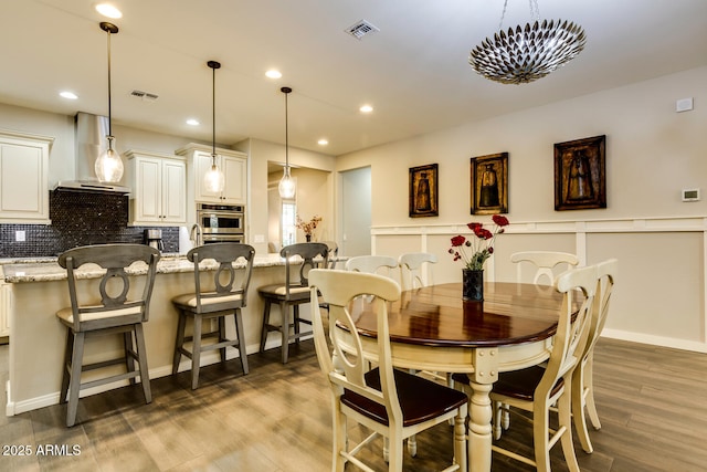 dining space with wood-type flooring and a notable chandelier