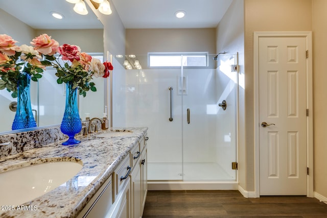 bathroom with hardwood / wood-style flooring, vanity, and walk in shower