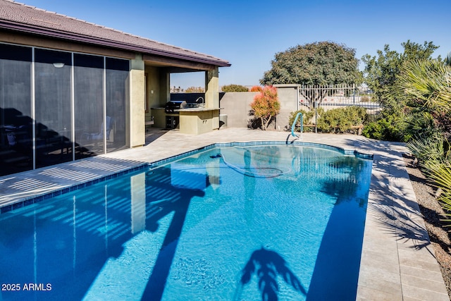 view of swimming pool featuring area for grilling and exterior kitchen