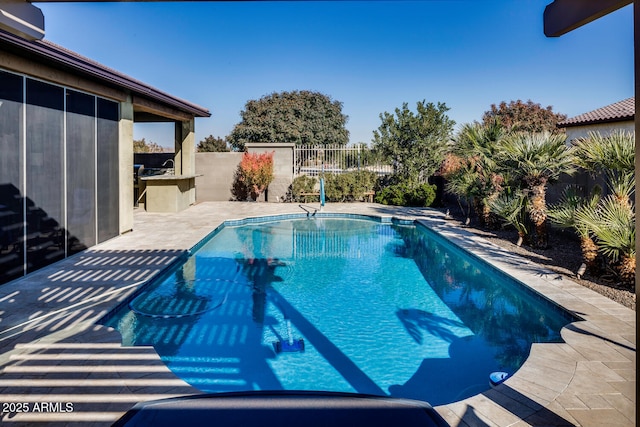 view of swimming pool featuring an outdoor kitchen and a patio area