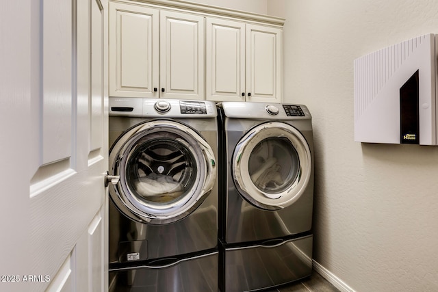 laundry area with washer and clothes dryer and cabinets