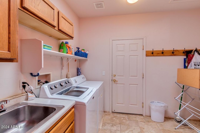 laundry area featuring cabinets, sink, and washing machine and clothes dryer