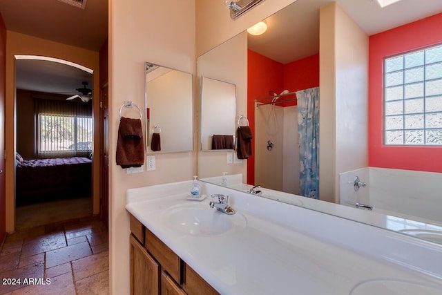 bathroom with ceiling fan, vanity, and walk in shower