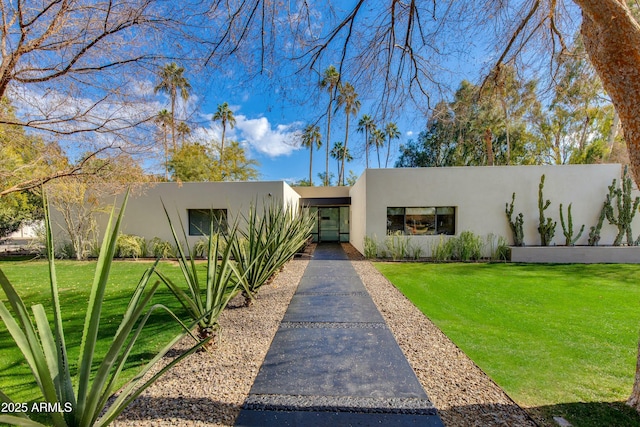 southwest-style home featuring a front lawn and stucco siding