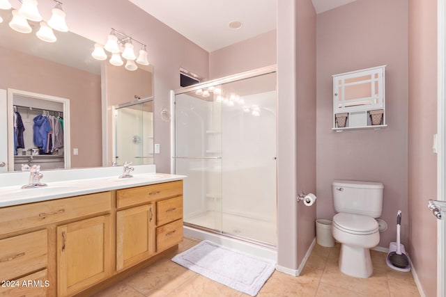 bathroom with vanity, toilet, walk in shower, and tile patterned flooring