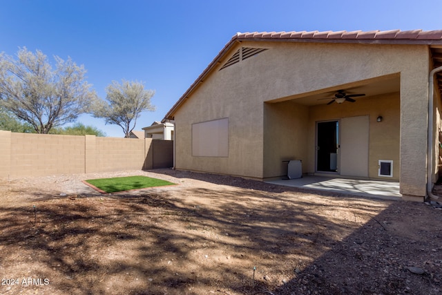 rear view of property featuring ceiling fan and a patio area