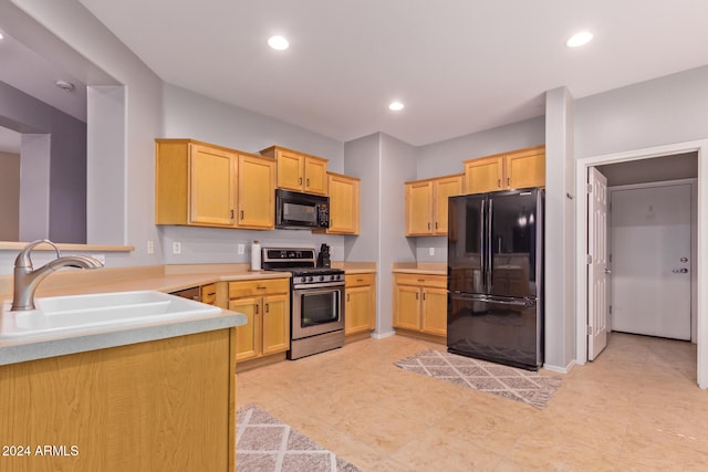 kitchen with kitchen peninsula, black appliances, sink, and light brown cabinetry