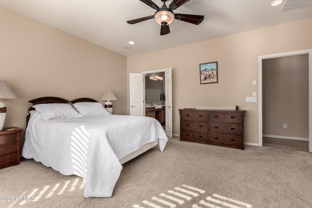 bedroom featuring connected bathroom, light colored carpet, and ceiling fan