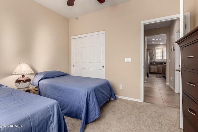 carpeted bedroom with stainless steel fridge, ceiling fan, and a closet