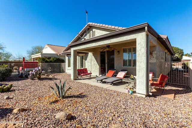 back of property with ceiling fan and a patio area