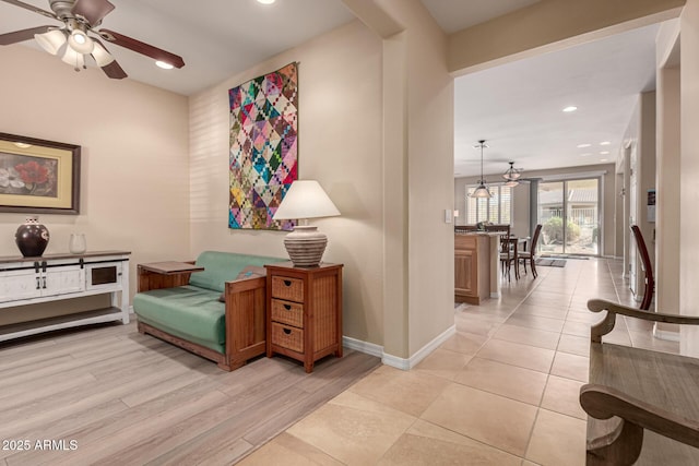 living area featuring ceiling fan and light wood-type flooring