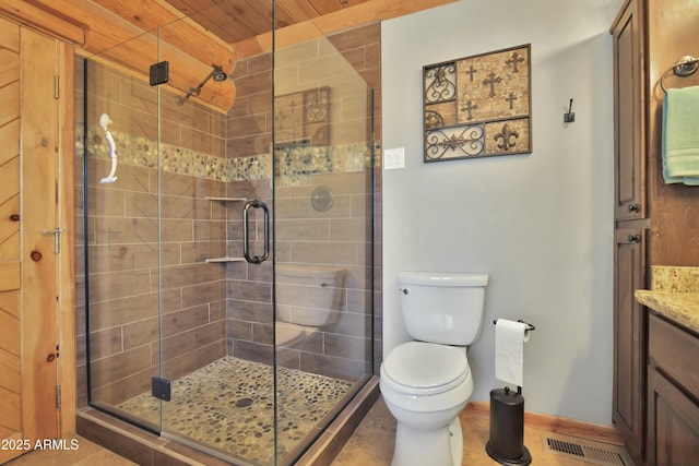 bathroom with vanity, toilet, tile patterned floors, and a shower with shower door