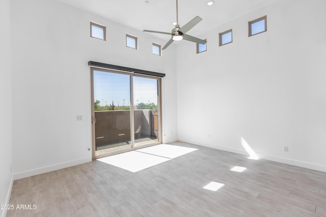 empty room featuring ceiling fan, baseboards, and wood finished floors