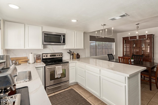9825 N 44th Ave, Glendale, AZ 85302 - kitchen with appliances with stainless steel finishes, a peninsula, white cabinets, light tile patterned floors, and recessed lighting