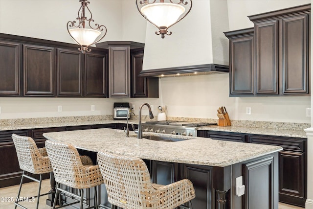 kitchen with a kitchen bar, custom exhaust hood, dark brown cabinets, and a center island with sink