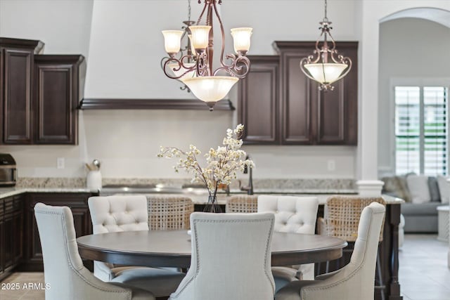 dining area with an inviting chandelier and arched walkways