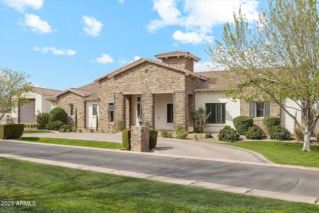 mediterranean / spanish home with a front lawn, a tiled roof, stone siding, and stucco siding