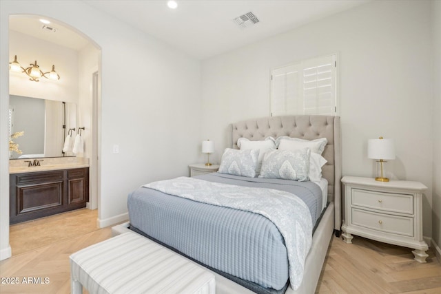 bedroom featuring visible vents, baseboards, recessed lighting, arched walkways, and a sink