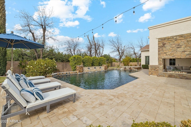 view of pool featuring a patio area, a fenced in pool, an outdoor stone fireplace, and a fenced backyard