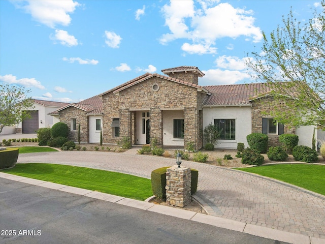 mediterranean / spanish-style house with stone siding, curved driveway, and a tile roof