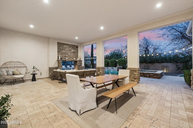 patio terrace at dusk featuring outdoor dining space and a fenced backyard