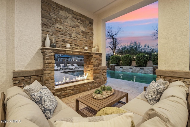 patio terrace at dusk with a fenced in pool and an outdoor hangout area