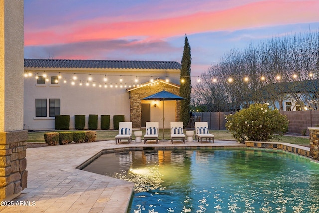 view of swimming pool featuring a patio area, fence, and a fenced in pool