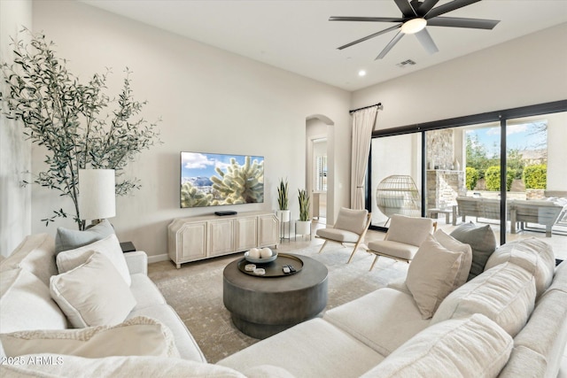 living room with baseboards, visible vents, recessed lighting, arched walkways, and ceiling fan