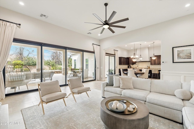 living room with light tile patterned flooring, visible vents, ceiling fan with notable chandelier, and recessed lighting