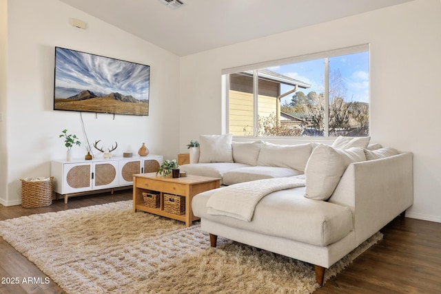 living area featuring lofted ceiling, visible vents, baseboards, and wood finished floors