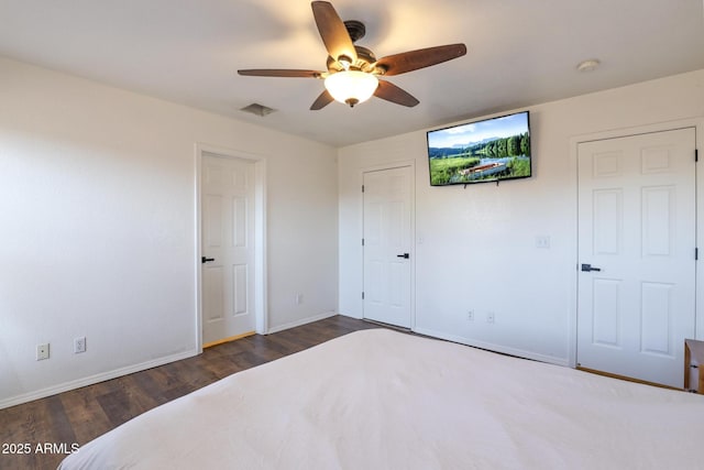 bedroom with ceiling fan, wood finished floors, visible vents, and baseboards