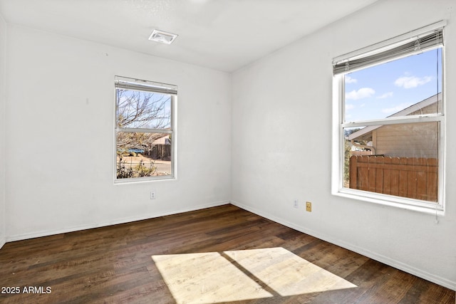 unfurnished room featuring visible vents, baseboards, and wood finished floors