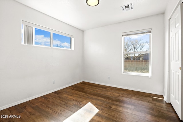 unfurnished bedroom with a closet, visible vents, dark wood finished floors, and baseboards