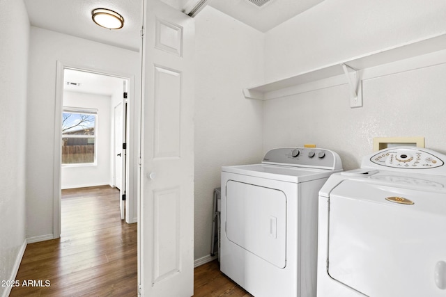 washroom featuring laundry area, dark wood-type flooring, independent washer and dryer, and baseboards