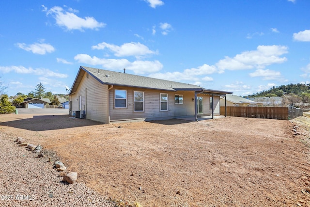 rear view of house with fence, cooling unit, and a patio