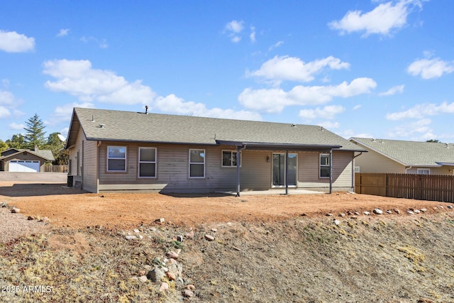 back of house with roof with shingles, fence, and a patio