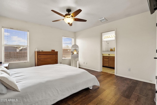 bedroom featuring visible vents, baseboards, a ceiling fan, wood finished floors, and ensuite bathroom