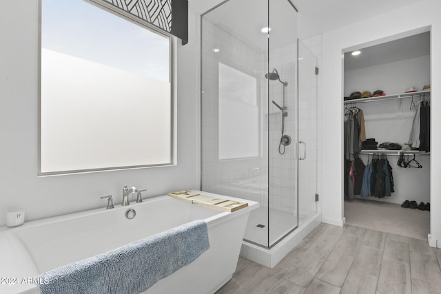 bathroom featuring hardwood / wood-style floors and plus walk in shower