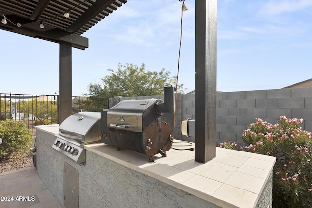 view of patio with an outdoor kitchen, area for grilling, and a pergola