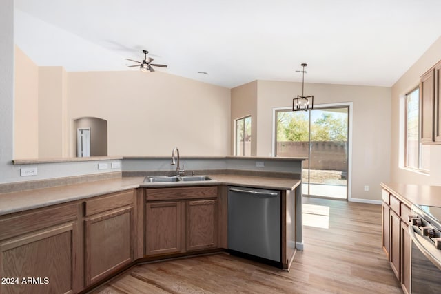 kitchen featuring appliances with stainless steel finishes, light hardwood / wood-style floors, vaulted ceiling, and sink