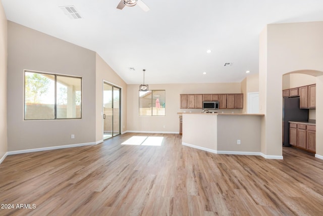 kitchen featuring hanging light fixtures, vaulted ceiling, ceiling fan, appliances with stainless steel finishes, and light hardwood / wood-style floors