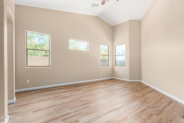 unfurnished room with plenty of natural light, lofted ceiling, and light hardwood / wood-style flooring