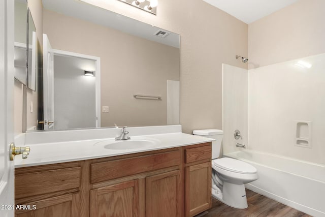 full bathroom with shower / bathing tub combination, wood-type flooring, vanity, and toilet