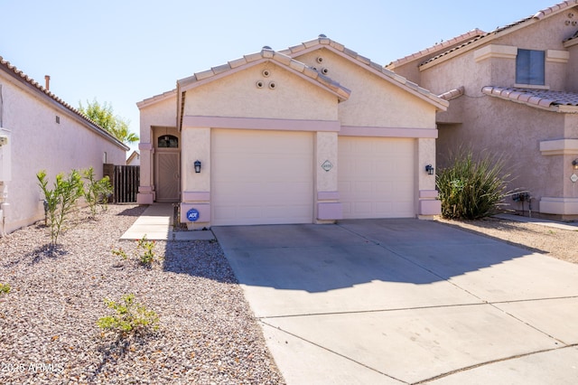 mediterranean / spanish house featuring a garage, driveway, a tiled roof, and stucco siding