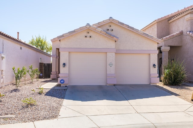 view of front facade featuring driveway, a tile roof, a garage, and stucco siding