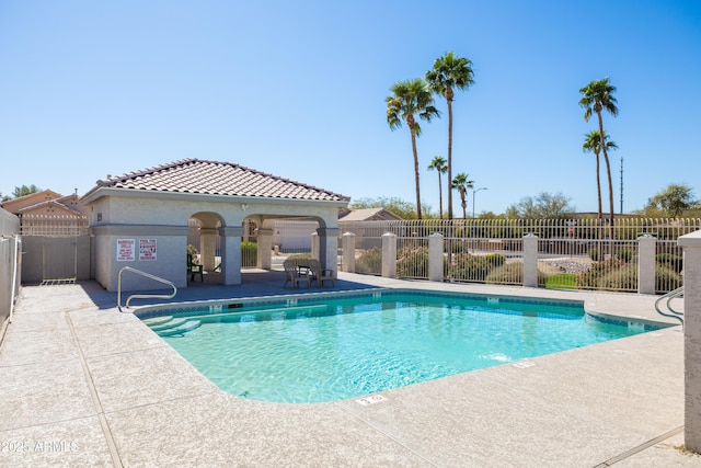 community pool with fence and a patio