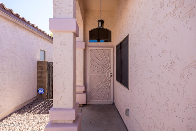 property entrance with a tile roof and stucco siding