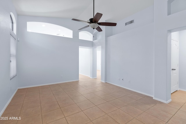 unfurnished room with high vaulted ceiling, ceiling fan, visible vents, and baseboards