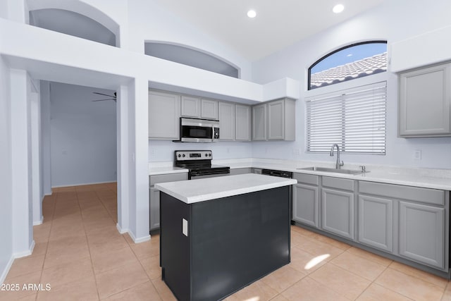 kitchen with appliances with stainless steel finishes, gray cabinets, a sink, and light countertops