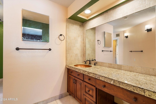 bathroom featuring baseboards, vanity, visible vents, and tile patterned floors